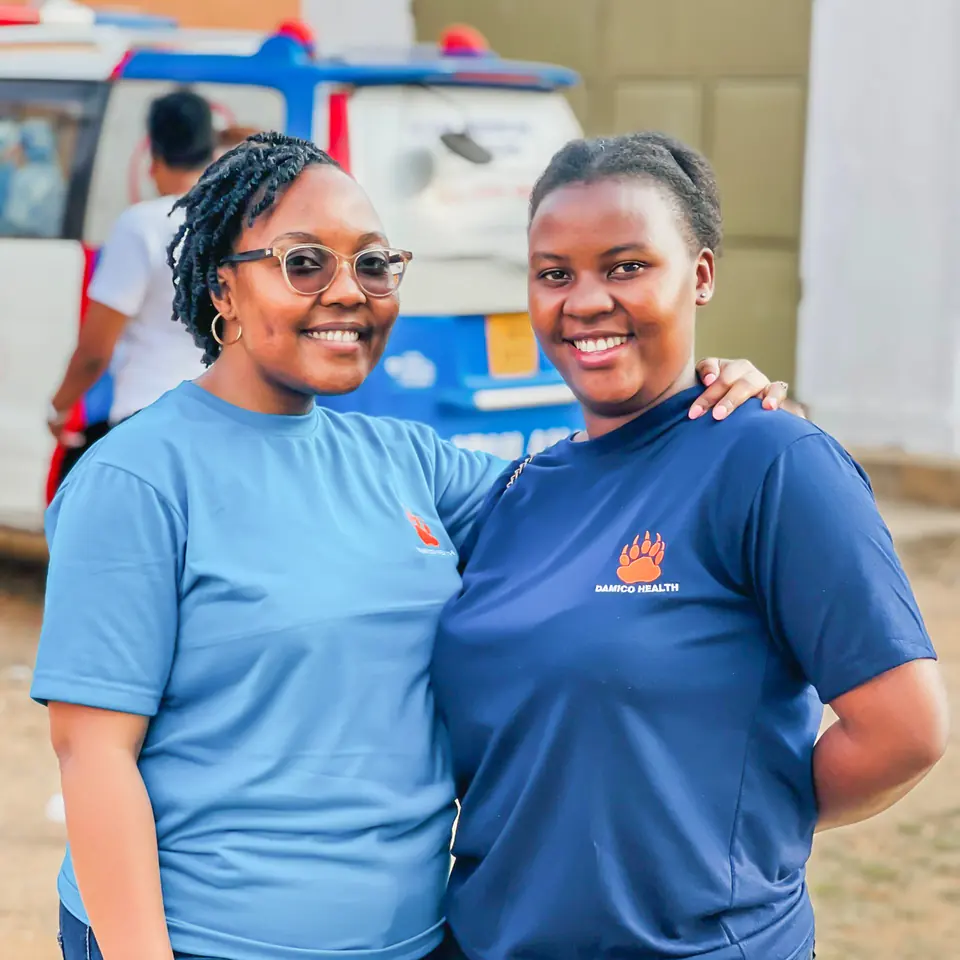 Two women on the Damico Health team stand together, smiling.