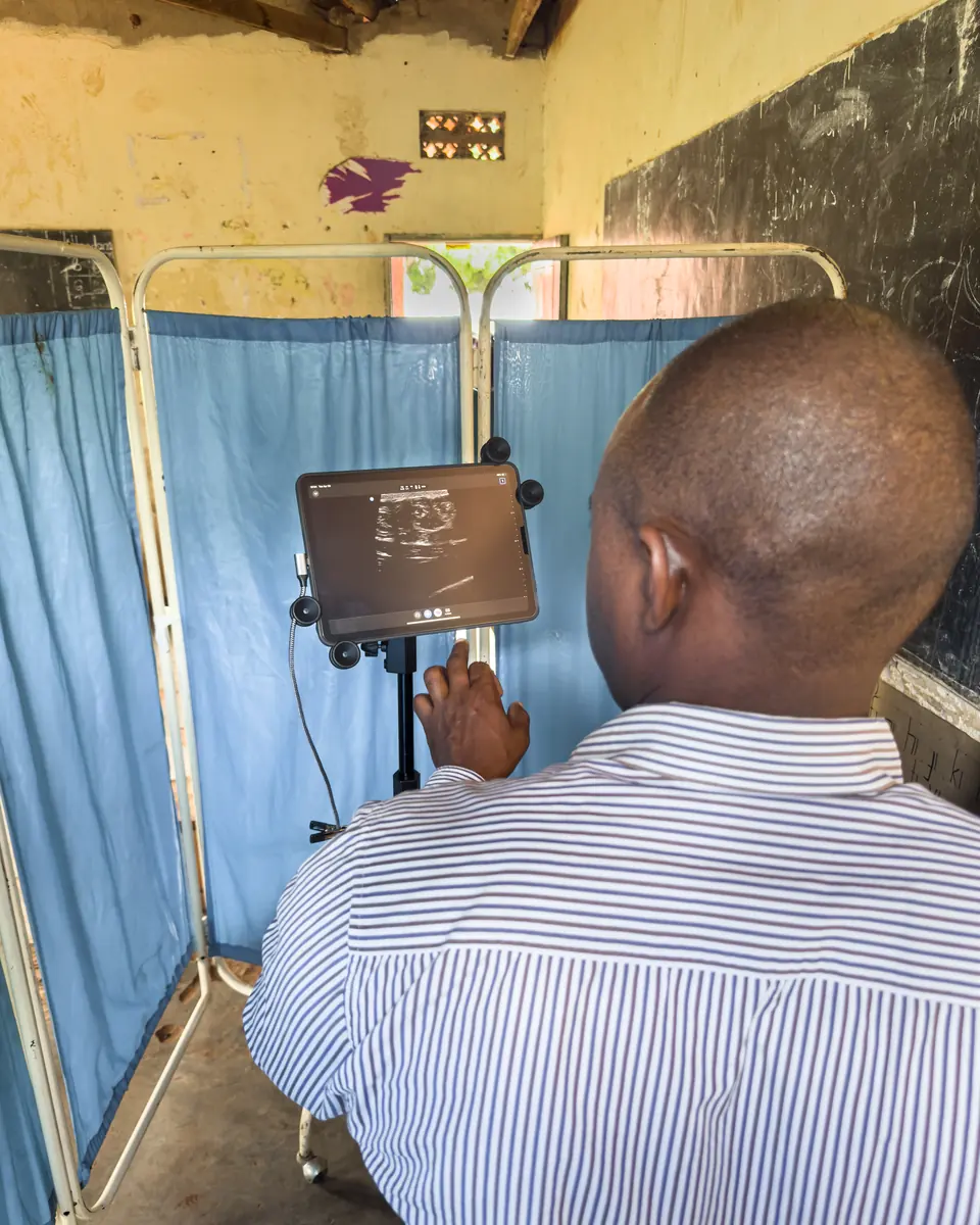 A clinician reviews a bedside ultrasound image on a tablet.
